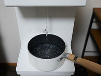 ピュアライフの水受けトレイに置いた鍋に水を注いでいる写真