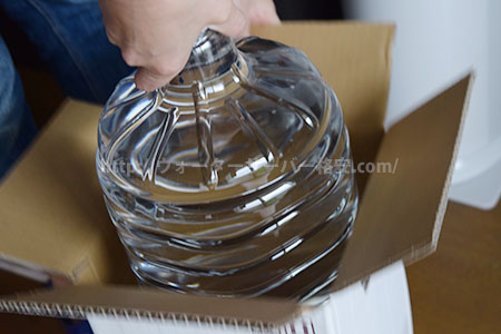 ダンボールから水ボトルを取り出す